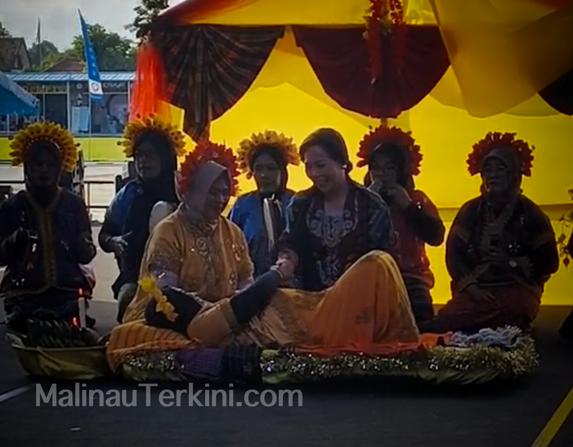 Bu Sekda Ikuti Kiri Loko Irau Malinau Seorang sando bersama tamu memimpin doa keselamatan bagi ibu hamil dalam prosesi adat Kiri Loko, disaksikan penonton di panggung Irau Malinau.