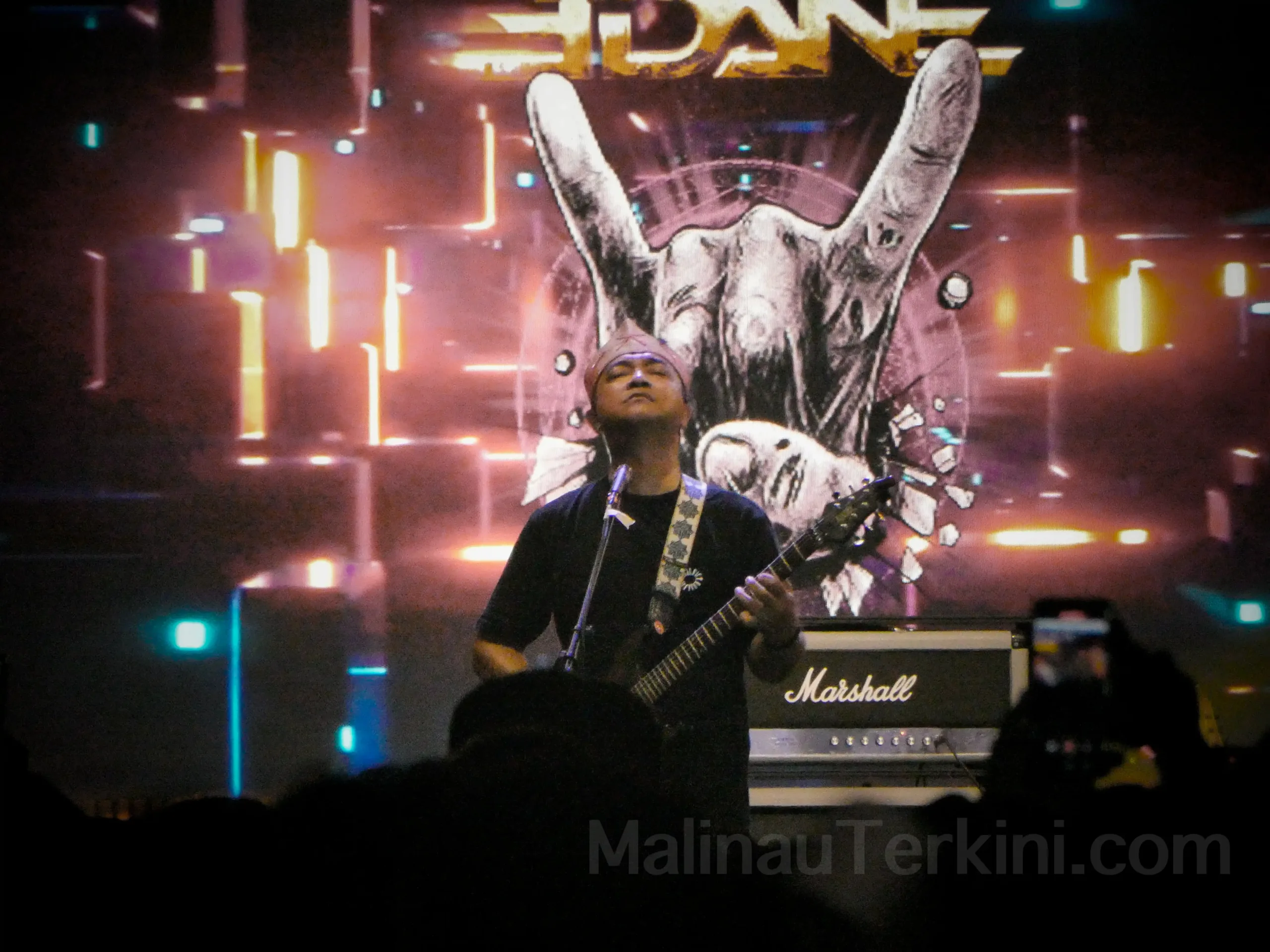 Gitaris Edane memainkan solo gitar ikonik yang membakar suasana konser Irau Malinau. Aksi panggung Edane menjadi salah satu momen paling ditunggu penonton. Foto: MalinauTerkini.com