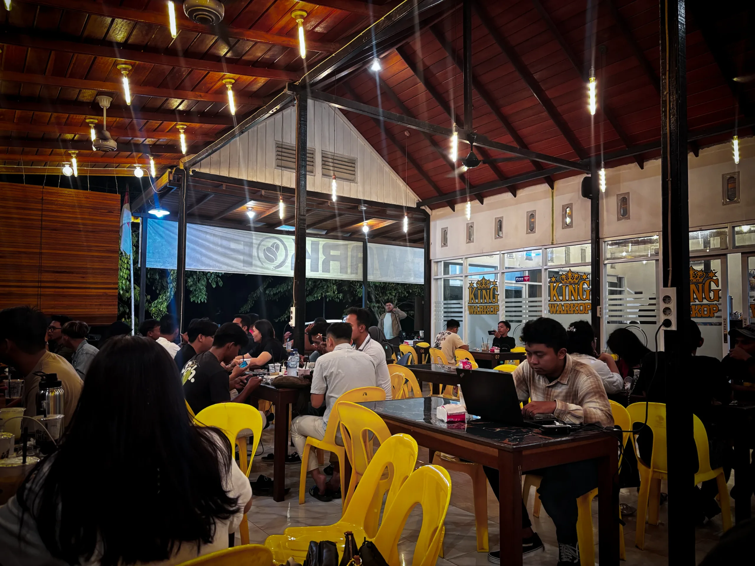 Suasana King Warkop di Malinau dengan area indoor ber-AC dan outdoor santai, ramai dikunjungi anak muda dan pekerja.