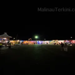Suasana Malam di Stan Irau Malinau 2025 Suasana malam di stan Irau Malinau tahun 2025 dengan keramaian pengunjung dan dekorasi lampu warna-warni.