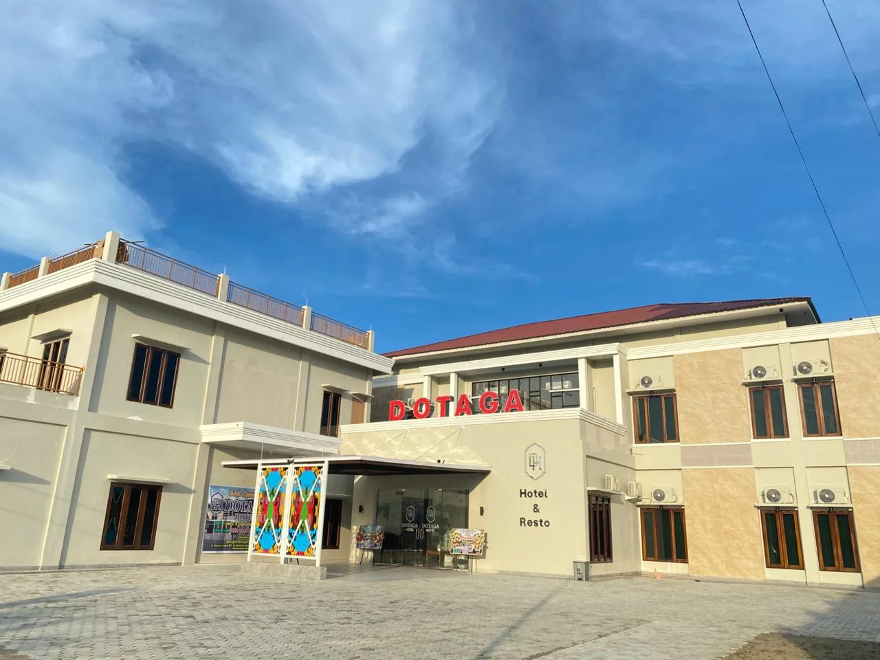 Tampak depan Hotel Dotaga Malinau dengan bangunan modern dua lantai dan area parkir luas.