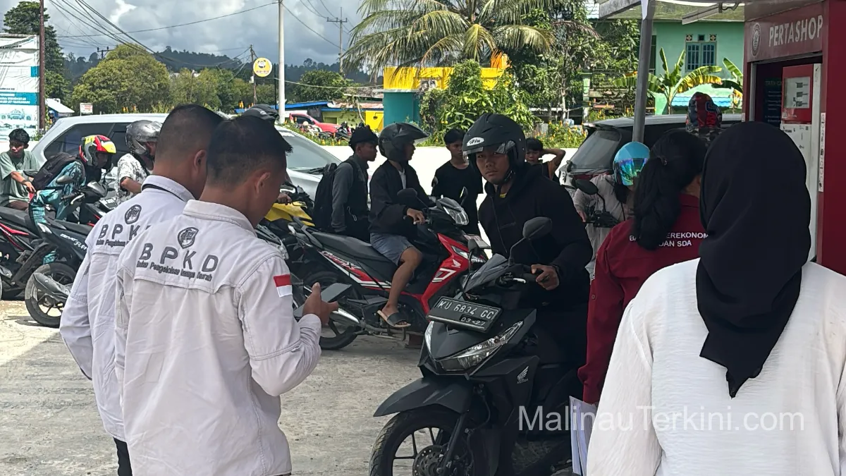 Petugas melakukan inspeksi dan pendataan penyaluran BBM kepada pengendara di sebuah Pertashop di wilayah Malinau Utara, disaksikan warga yang sedang mengantre.