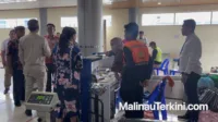 malinauterkini_23 Des 2025, 11.31 Suasana di area lapor diri (check-in) Bandara Malinau yang memperlihatkan penumpang sedang berinteraksi dengan petugas di depan meja pelayanan.