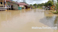 Foto pemukiman warga di Kabupaten Malinau yang terendam banjir dengan debit air yang tinggi menutupi badan jalan dan halaman rumah.