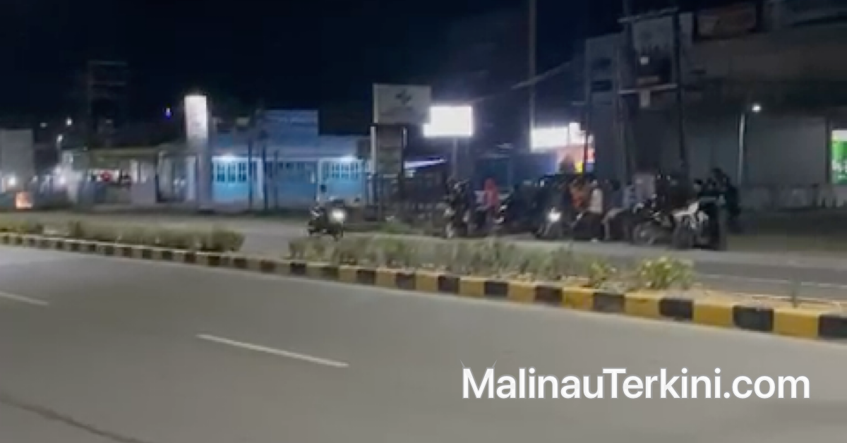 Deretan sepeda motor yang terparkir di bahu jalan dengan latar belakang lampu jalan umum (LPJU) yang menyala terang di kawasan Bandara malinau