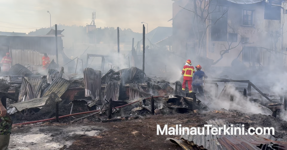 Petugas Damkar Malinau melakukan pendinginan di sisa bangunan yang hangus terbakar.