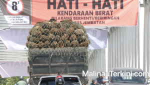 Arus lalu lintas kendaraan roda dua melintas di bawah spanduk peringatan pembatasan beban Jembatan Malinau.