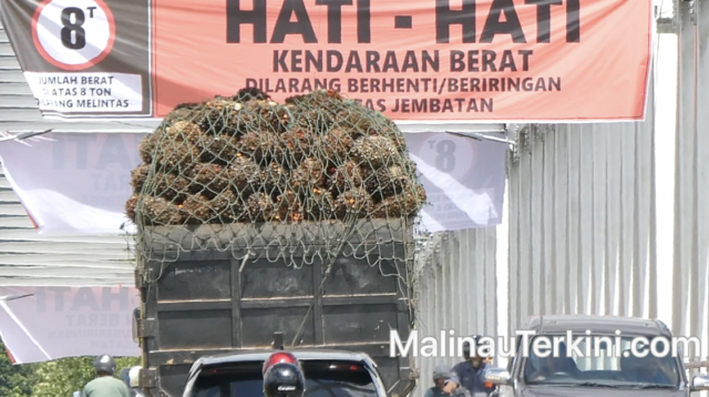 Arus lalu lintas kendaraan roda dua melintas di bawah spanduk peringatan pembatasan beban Jembatan Malinau.