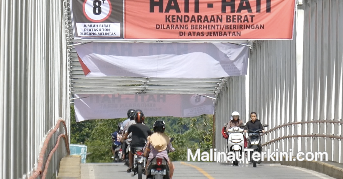 Arus lalu lintas kendaraan roda dua melintas di bawah spanduk peringatan pembatasan beban Jembatan Malinau,
