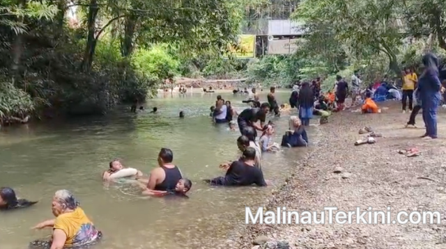 Wisatawan menikmati suasana liburan di Malinau dengan berenang di sungai Tana Olen saat cuti bersama Idul Adha 2026.